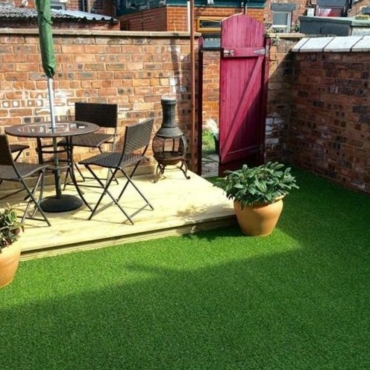 a small garden with deck area and artificial grass