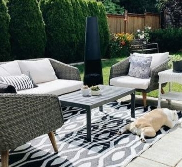 a concrete patio with an outdoor rug and patio furniture