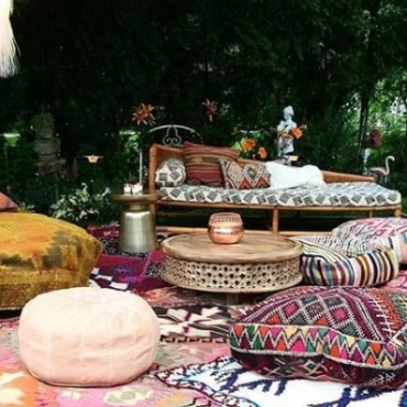 bohemian garden ideas - garden seating laid out on grass with patterend rugs and floor cushions