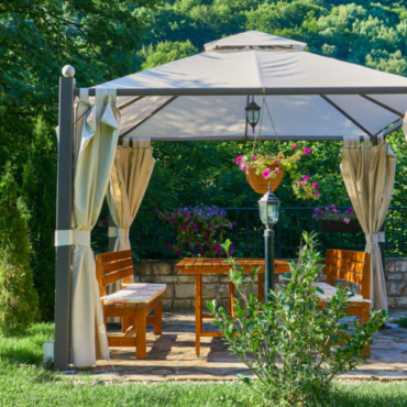 a metal-framed gazebo with luxurious canvas curtains
